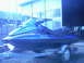 1994 Ford Bronco - A blue jet ski is parked on a trailer outside a building.